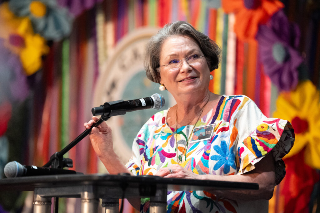 Pam Voss, Executive Director of C.A.M.P. University, welcomes guests during the gala.